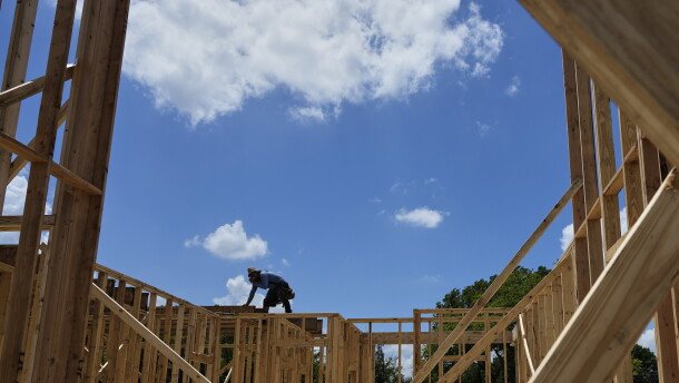 Workers work on the roofing structure of new home under construction, Tuesday, July 15, 2025, in Richardson, Texas.