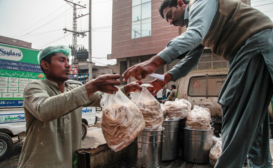 Workers at the Pakistani charity Saylani load freshly-cooked flat bread, or naan, into an open-backed jeep. The food will be distributed to 40 free cafeterias run by the charity in the city of Faisalabad. It's a place considered prosperous by Pakistani standards, but the charity says workers are going hungry because soaring inflation means they can't afford food.