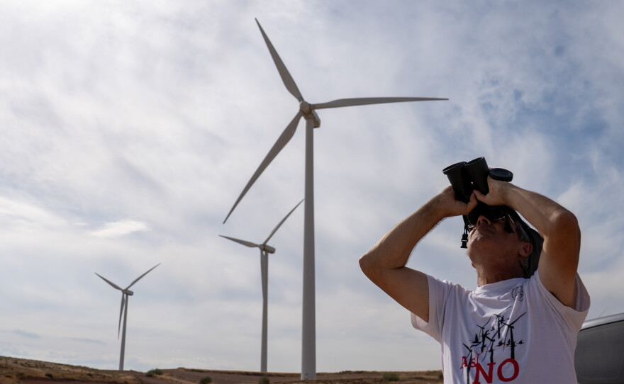Ornithologist José Antonio Pinzolas looks for raptors and vultures, flying near dozens of windmills, in Rueda de Jalón, Spain, on Sept. 27.