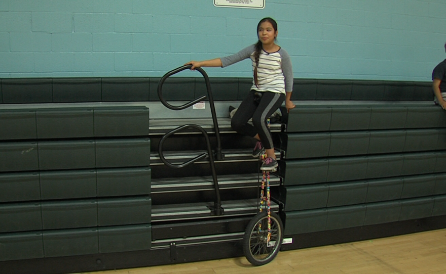 Ten-year-old Cinthia Cruz balances on a the five-foot-tall unicycle nicknamed "the giraffe" at the Fern Street Circus after-school program at the Mid-City Gym in City Heights, Jan. 30, 2018.
