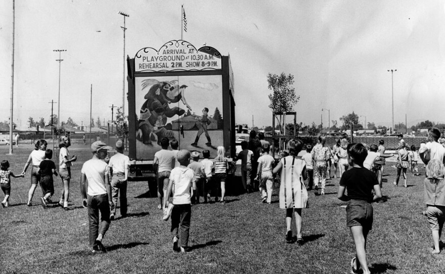 Children follow a truck as it drives into position at Granada Hills Playground to set up the 1964 Combined Traveling Circus and Kiddie Carnival, July 4, 1964.