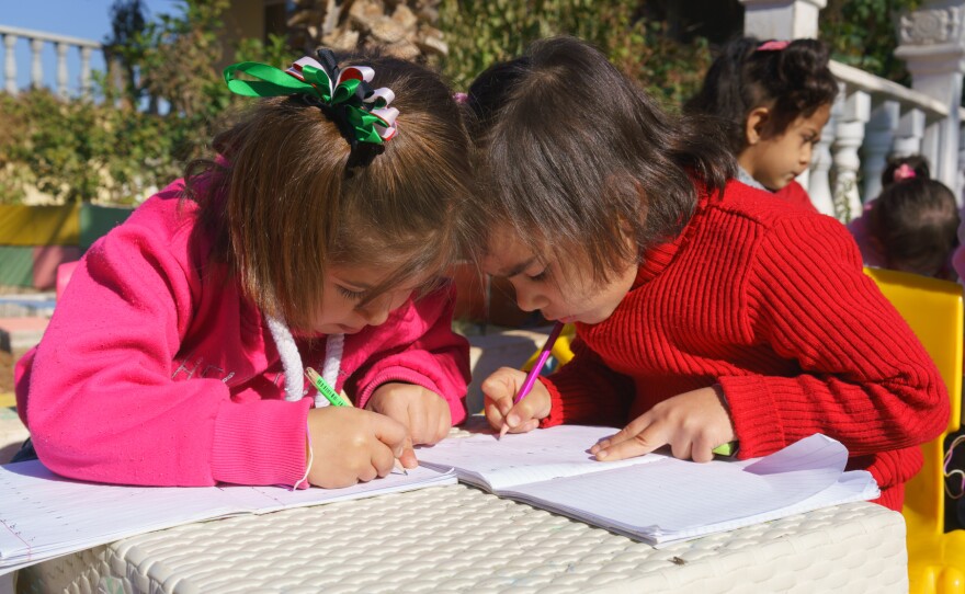 Two Syrian girls color at Bayti orphanage in Reyhanli, Turkey, just across the border from Syria. Many young Syrian refugees have lost one or both parents, but space is limited at orphanages in the city.