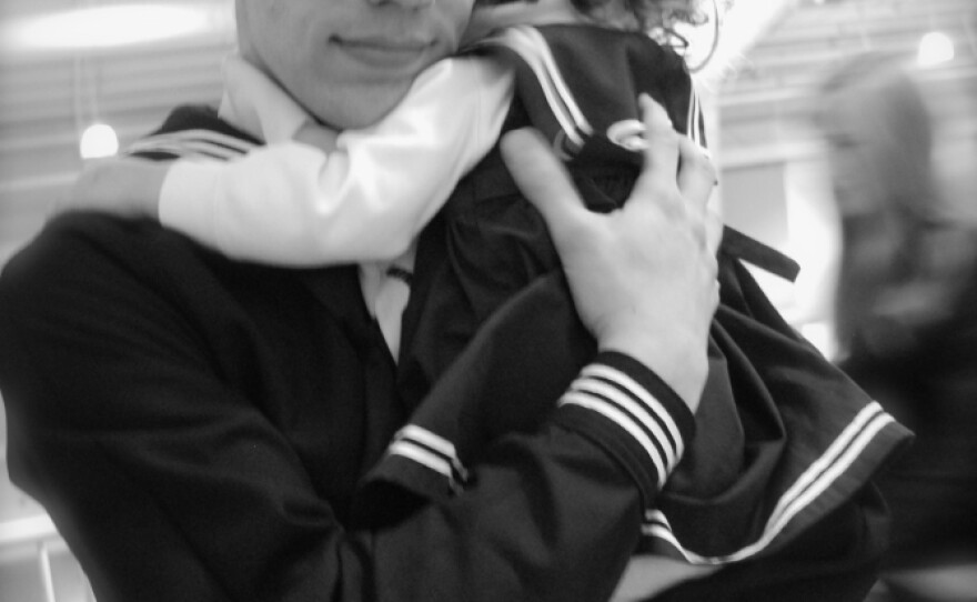 Justin Bock holds his daughter, Lina, at his graduation from basic training earlier this year. Bock decided to enlist in the Navy after both he and his wife, Ashley, were laid off.