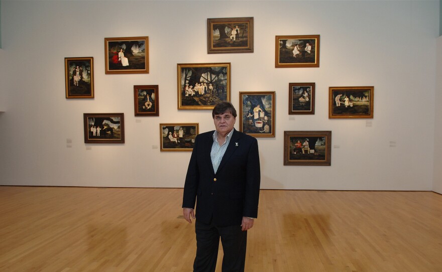 Artist George Rodrigue poses with some of his Cajun heritage paintings.