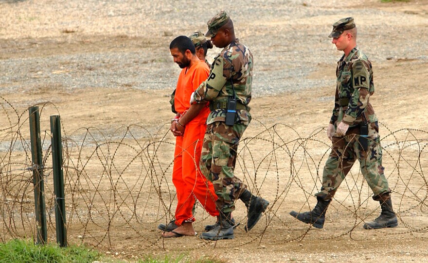 Marines transport a detainee in Guantánamo Bay, Cuba, in 2002. Nearly 800 detainees have passed through the prison since it opened that year. Today, 39 men are still being held there.