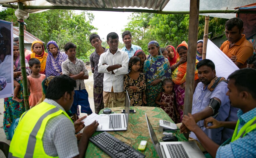 Patients line up for remote health consultation sessions on a char near Rangpur, Bangladesh.