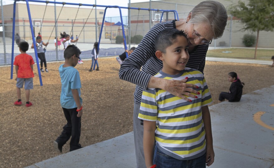 An office administrator embraces the exuberant Humberto in a rare moment of calm during recess.