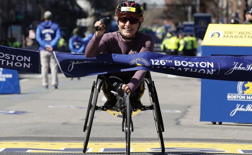 Manuela Schar, of Switzerland, hits the tape to win the women's wheelchair division of the 126th Boston Marathon on Monday.
