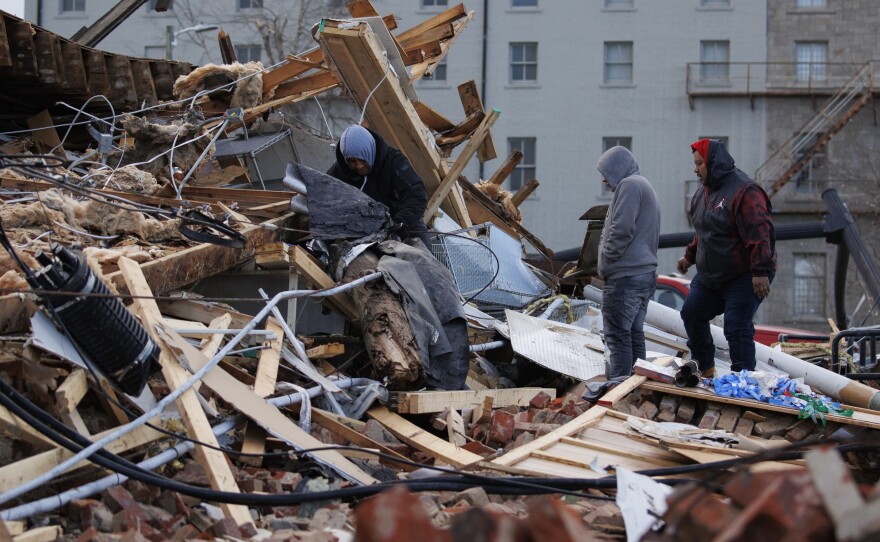 People search through a storm-damaged building on Saturday in Mayfield, Ky. Multiple tornadoes tore through parts of the lower Midwest late on Friday night leaving a large path of destruction.