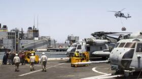 A U.S. Navy MH-60S Seahawk helicopter transports food and supplies to the USS San Antonio on July 9, 2013.
