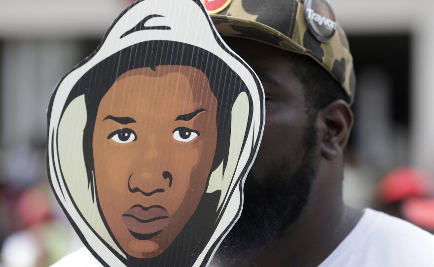 Aqua Etefia holds up a Trayvon Martin mask at a rally Saturday in Miami.