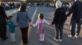 Five-year-old Rachel Crabb (center) holds hands with  teachers, parents and other students during a moment of silence for her slain  schoolmate, Christina Green, at Mesa Verde Elementary School in Tucson, Ariz., earlier this week.