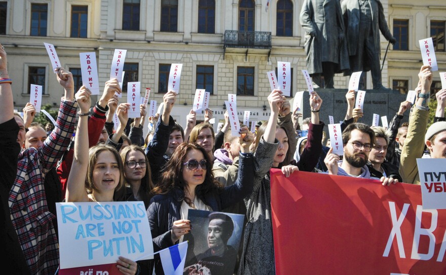 People hold sheets reading "enough" as they protest in downtown Tbilisi, Georgia, on Sunday.