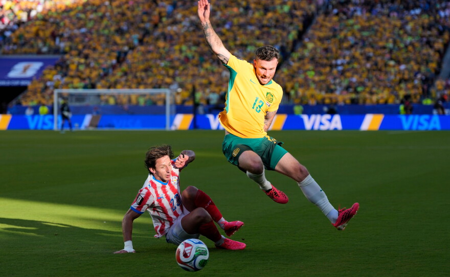 Australia's Aiden O'Neill (13) battles for the ball with Paraguay's Matias Galarza (23) during the World Cup Group.