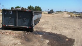 Trash trucks dump their loads in this dusty lot in National City. Local officials plan to convert this brownfield into a site for eco-friendly, low-income housing with green space and a community garden. 