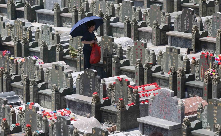 A mourner walks through a cemetery in Jinjiang during the Tomb-Sweeping Festival in 2015.