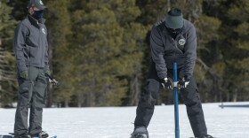 Assisted by Anthony Burdock, left, Sean de Guzman, chief of snow surveys for the California Department of Water Resources, checks the depth of the snowpack during the second snow survey of the season at Phillips Station near Echo Summit, Calif., Tuesday, March. 2, 2021. 