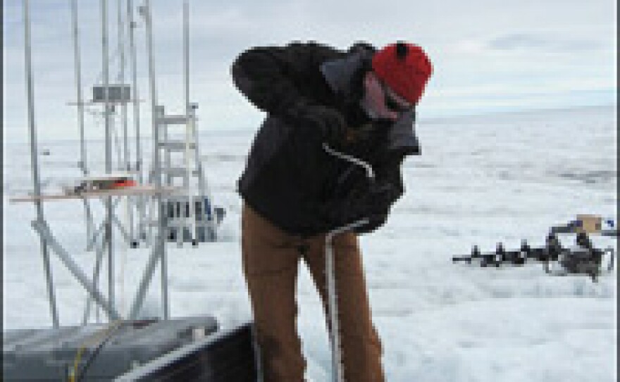 Ian Joughin from the University of Washington uses an ice drill to sink a pole into the surface. The pole will anchor his equipment, which includes an instrument that measures ice-quakes and another that tracks the movement of the ice.