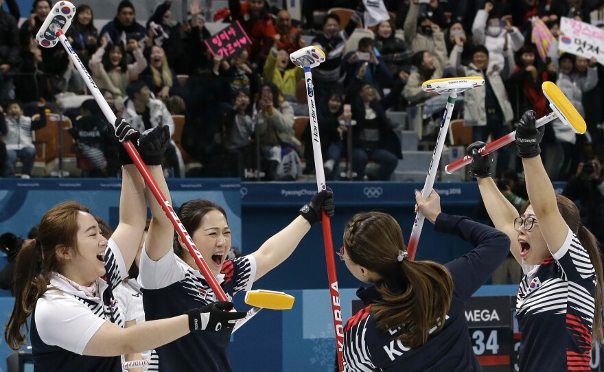 Members of the South Korean women's curling team celebrate after their semifinal victory over Japan on Friday. The upset puts the team, which has become a sensation in the Olympic host country, into a gold medal round match-up with Sweden.