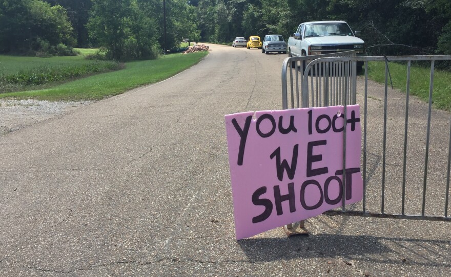 A handmade sign offers a stern warning at the entrance to an abandoned neighborhood where people have lost so much.