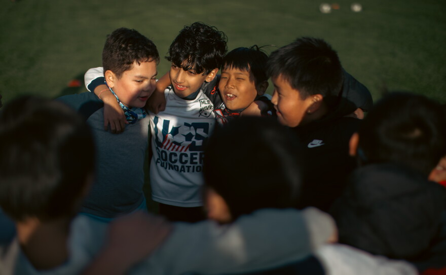 Children in Asian Refugees United's Soccer for Success program huddle during soccer practice in Harrisburg, Pa., on April 16, 2025.