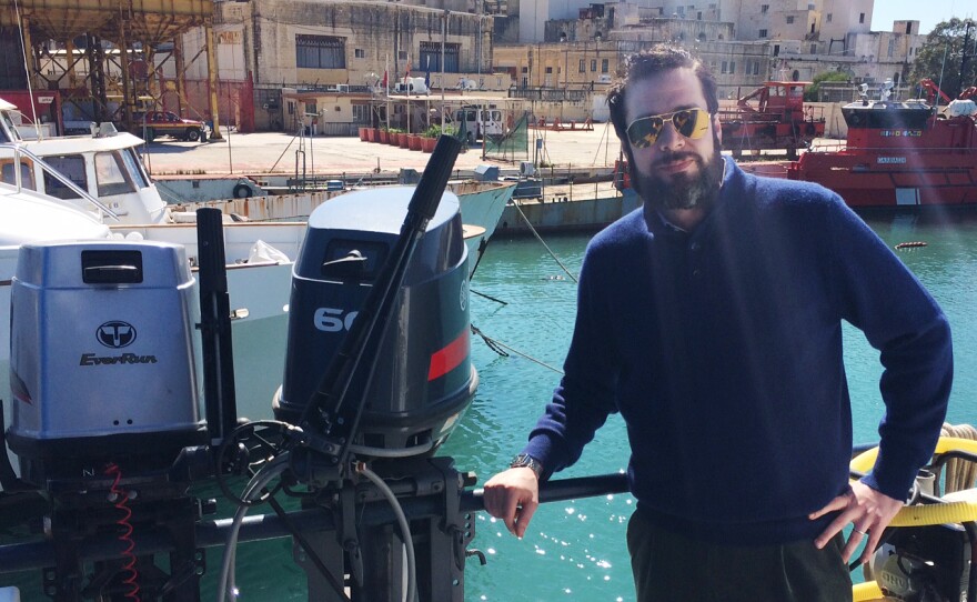 Christopher Catrombone stands in front of the ship that MOAS uses for sea rescues, the Phoenix, docked in Malta.
