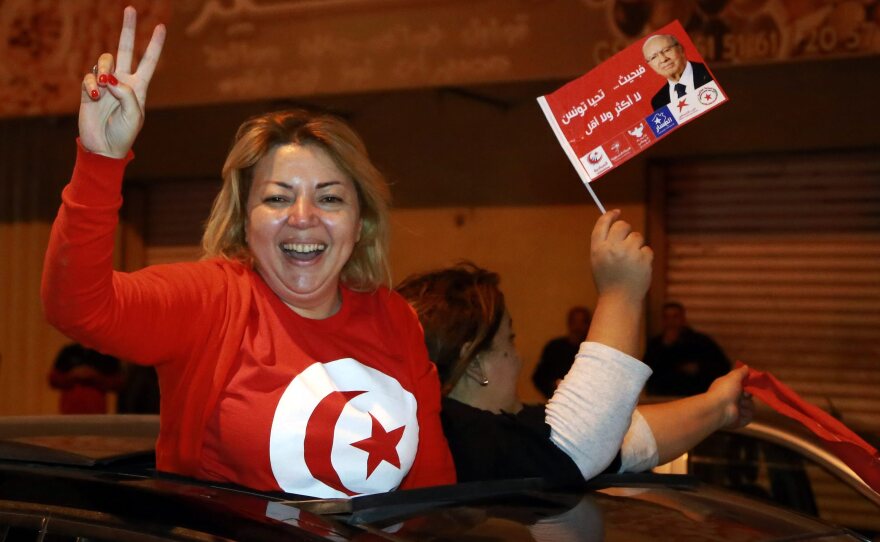 A supporter of newly elected Tunisian presidential candidate Beji Caid Essibsi flashes the V-sign from a car as they celebrate the first results of the Tunisian elections in Sousse, Tunisia.