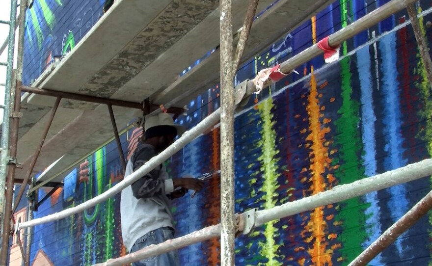 JoeNathan Segura works on a mural in the Lincoln Park neighborhood, Dec. 6, 2016.