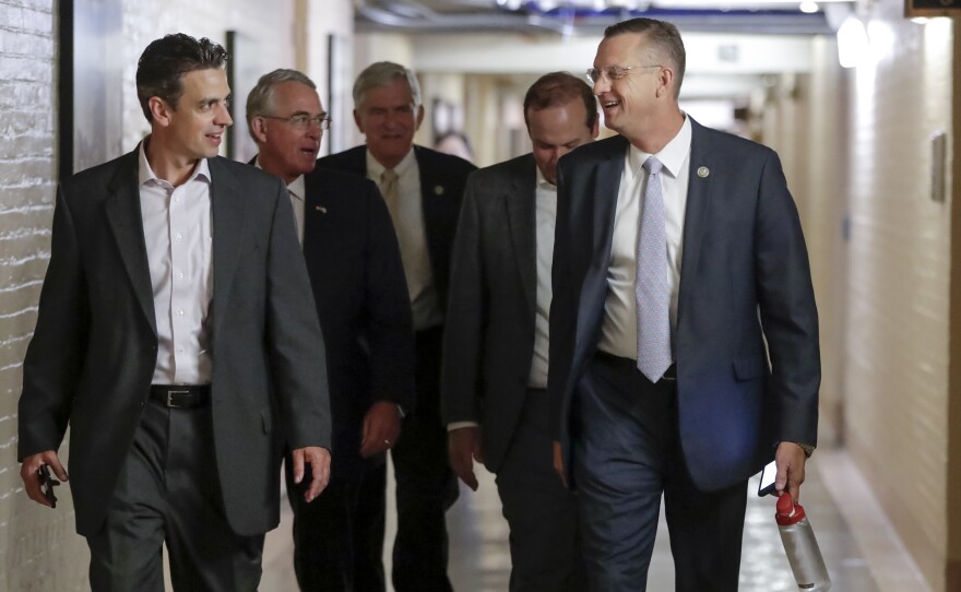 Rep. Justin Amash, R-Mich., far left, and Rep. Doug Collins, R-Ga., far right, head to a meeting with fellow Republicans on Capitol Hill in Washington, Friday, July 14, 2017, to reconcile the GOP's long-overdue budget blueprint, even as divisions between moderates and conservatives over cutting programs like food stamps threaten passage of the measure. 
