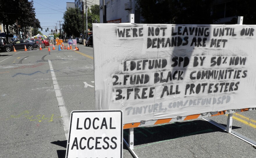 The Seattle Police Department will return to their East Precinct building "in the near future," Mayor Jenny Durkan says. Here, a sign on a street barricade lists protesters' demands in the Capitol Hill Occupied Protest zone, where two shootings took place over the weekend.