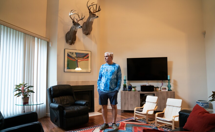 John Papadopoulos stands in the rental home in Houston where he and his family moved after their house flooded. The taxidermied deer are among the few items they were able to rescue from their flooded home.