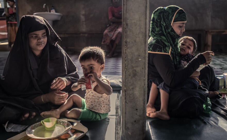 Rohingya refugees feed their malnourished children at a feeding center in Kutupalong camp.