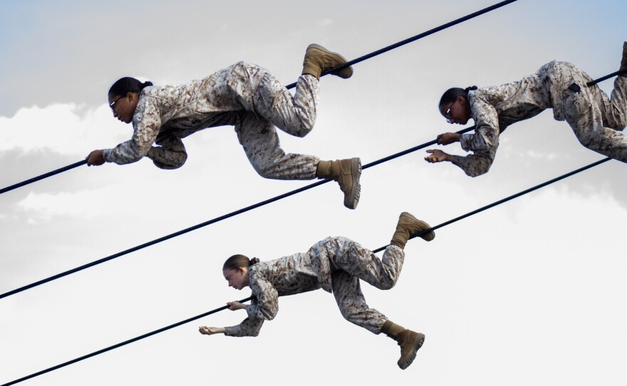 Female Marine recruits climb across ropes during the confidence building stage of their boot camp training at Camp Pendleton, March 9, 2021.