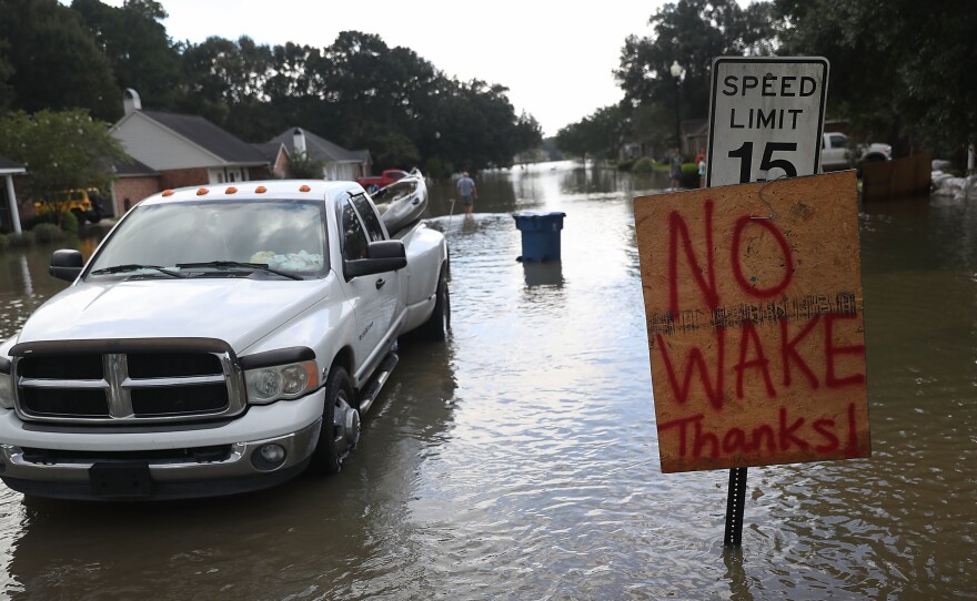 A "no wake" sign is seen along side a street in a residential neighborhood inundated with floodwaters this week in Sorrento, La.