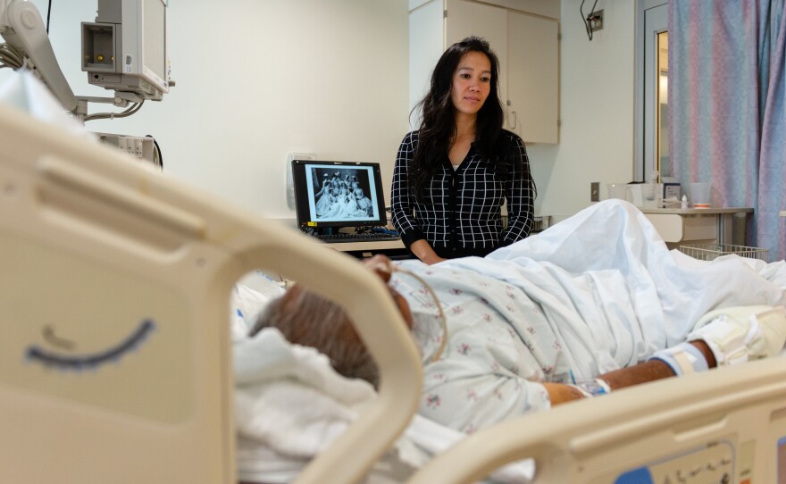 Lenh Vuong, a clinical social worker at Los Angeles County+USC Medical Center, checks on a former John Doe patient she recently helped identify.