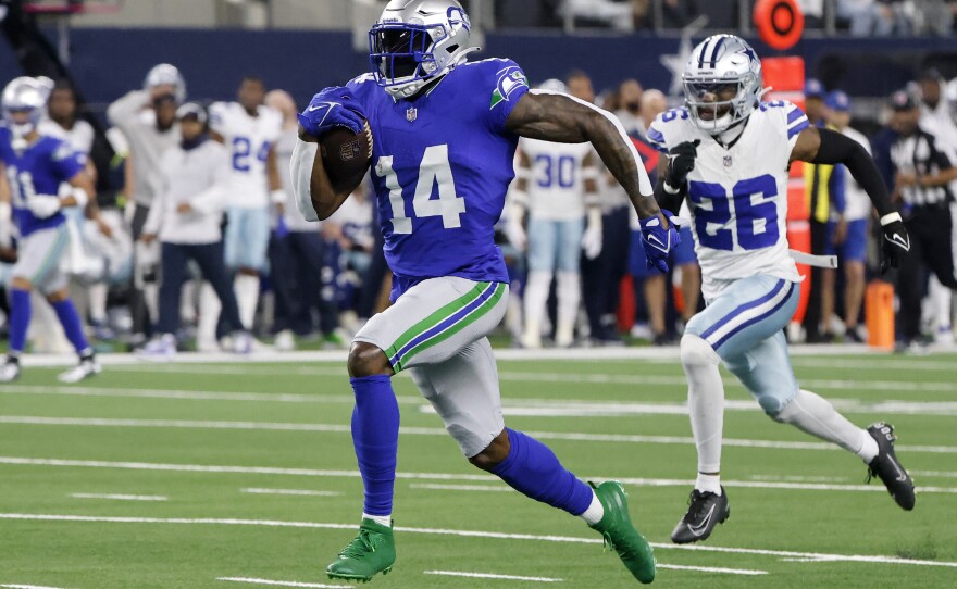 Seattle Seahawks wide receiver DK Metcalf (14) sprints to the end zone to score a touchdown as Dallas Cowboys cornerback DaRon Bland (26) gives chase in the first half of an NFL football game in Arlington, Texas, Thursday, Nov. 30, 2023.