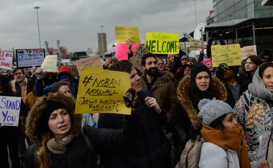 Protesters rally outside Kennedy International Airport to protest Trump's executive order on Saturday. New York City officials and immigrant advocates are holding are also holding a vigil at the airport Saturday evening.