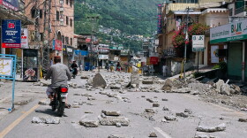 Motorcyclists navigate through a road barricaded with concrete blocks set up by supporters of the outlawed Joint Awami Action Committee (JAAC) during a protest demanding greater political rights and the abolition of 12 legislative refugee seats, in Muzaffarabad, the capital of Pakistan-administered Kashmir, Saturday, Aug. 1, 2026.