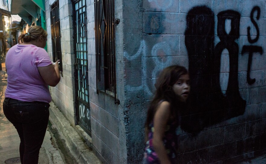 Mother and daughter hang around the streets of a residential area in San Salvador controlled by the gang Barrio 18.