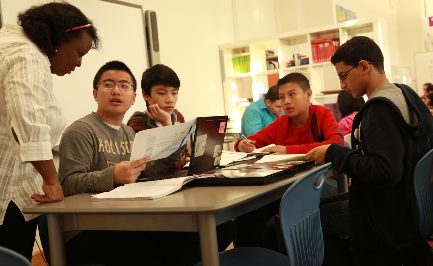 Students engaged in group work, being led by a teacher.