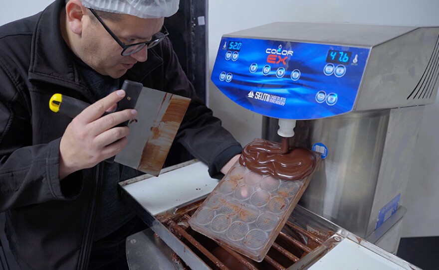 Host Jorge Meraz makes chocolate coins at the Kajkab Chocolate Factory in Tecate, Baja Calif.