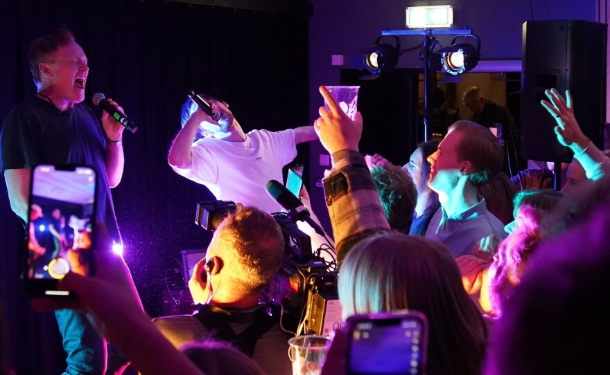 O'Brien performs onstage with a fan in Norway