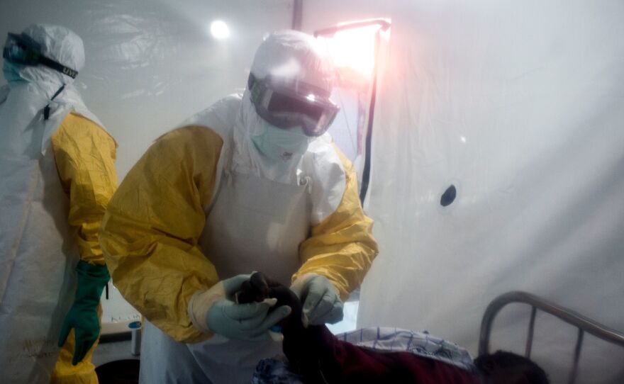 An Ebola patient is being checked by two medical workers on Wednesday in Beni, in the Democratic Republic of the Congo's North Kivu region.