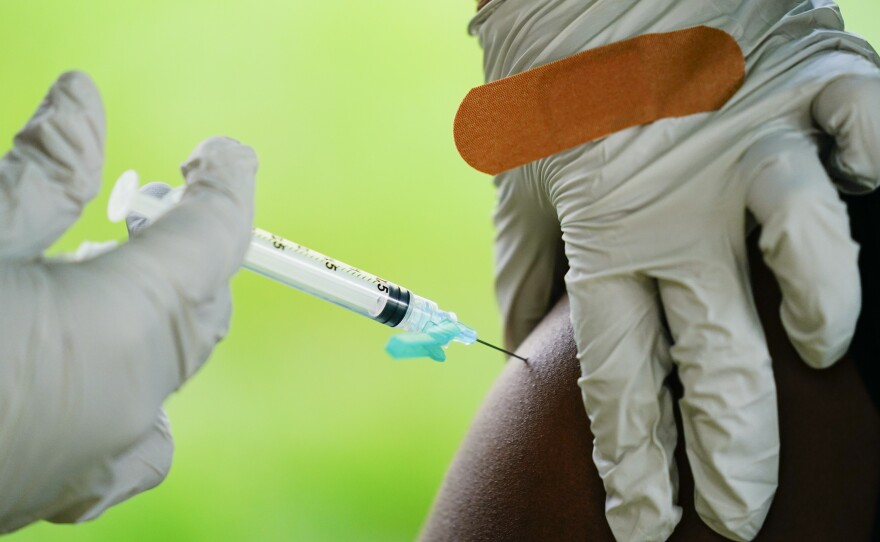 In this Sept. 14, 2021, file photo, a health worker administers a dose of a Pfizer COVID-19 vaccine during a vaccination clinic at the Reading Area Community College in Reading, Pa.