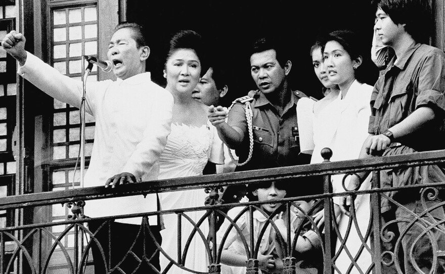 Ferdinand Marcos, with his wife Imelda at his side and Ferdinand Marcos Jr., far right, gestures from the balcony of Malacanang Palace on Feb. 25, 1986, in Manila, after taking the oath of office as president of the Philippines. The family fled to the U.S. shortly thereafter.