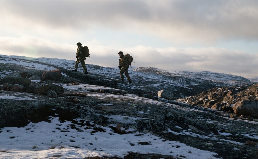Two privates walk on the mountain just outside the border post.