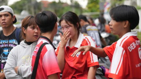 A schoolgirl cries outside her school where deaths and injuries were reported after a shooting in Thailand's Nonthaburi province, Friday, Aug. 7, 2026.