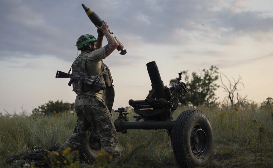 A Ukrainian serviceman of the 3rd Assault Brigade prepares to fire a mortar toward Russian positions near Bakhmut, Donetsk region, Ukraine, Sunday.