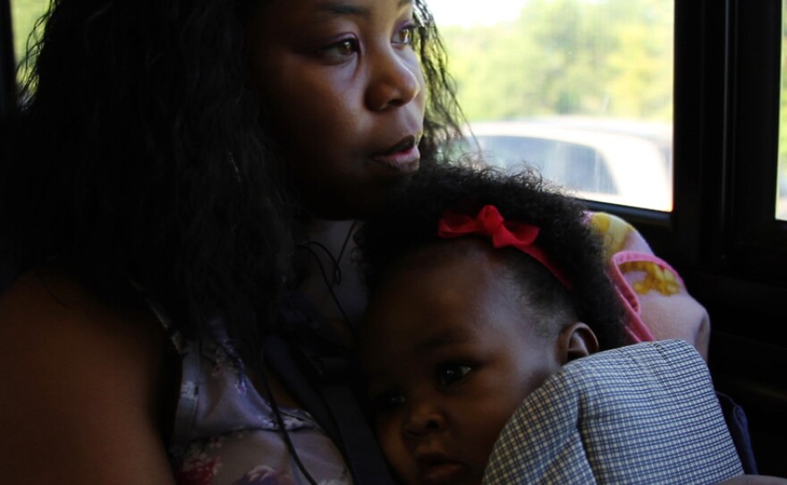 Raven Coston, a junior, makes her way to school on the bus with her young daughter Serenity.