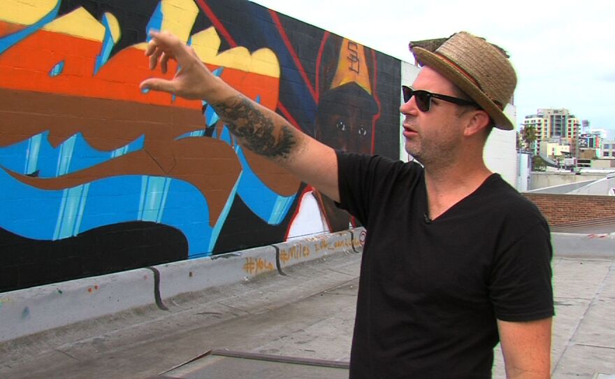 Artist Saratoga Sake explains the work he has to finish on the mural, July 18th, 2014